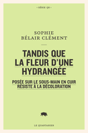 Tandis que la fleur d'une hydrangée posée sur le sous-main en cuir résiste à la